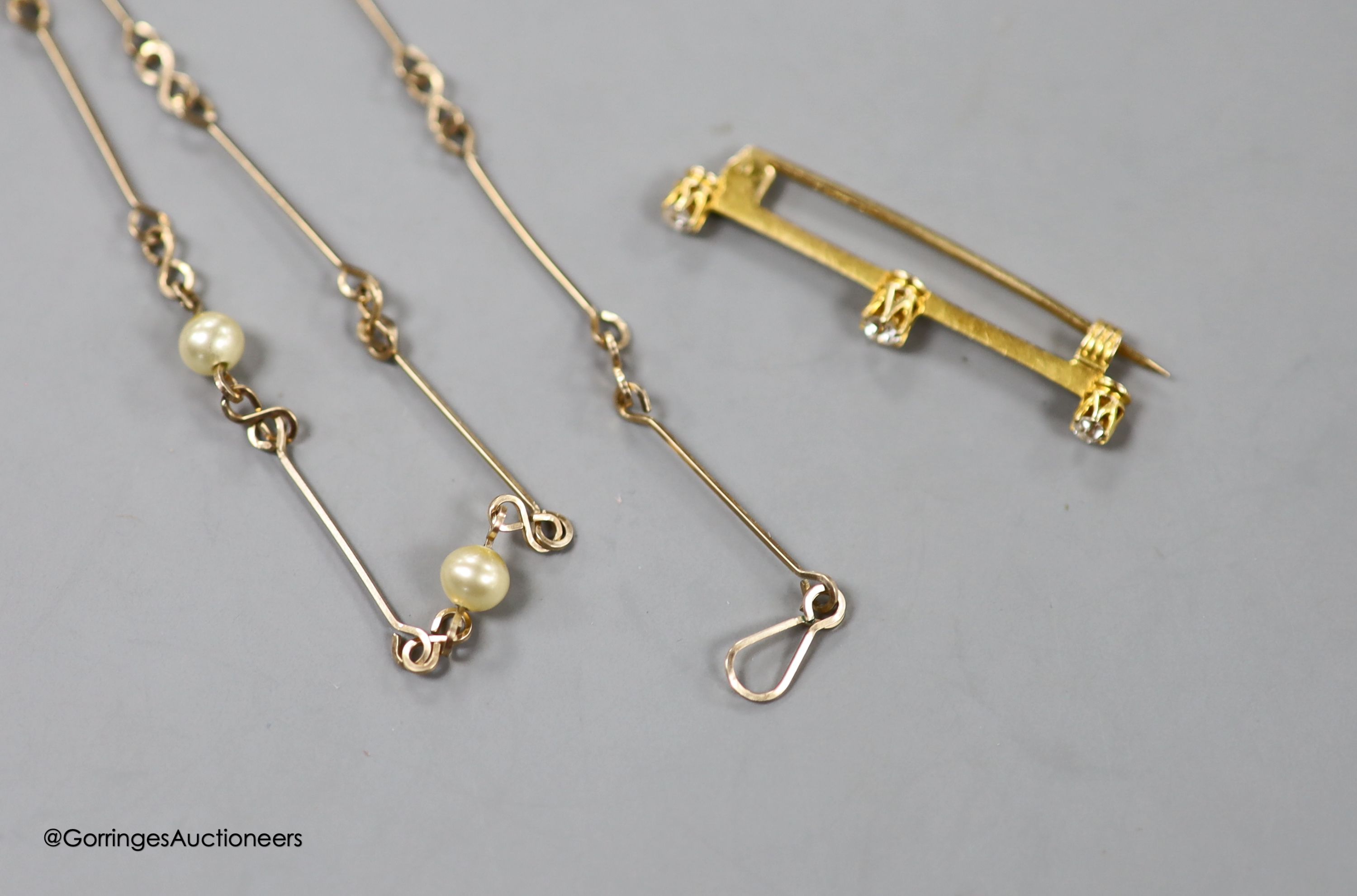 An early 20th century yellow metal and three stone diamond set bar brooch, 36mm, gross 1.6 grams and a yellow metal and simulated pearl set neck chain, 47cm, gross3.8 grams.